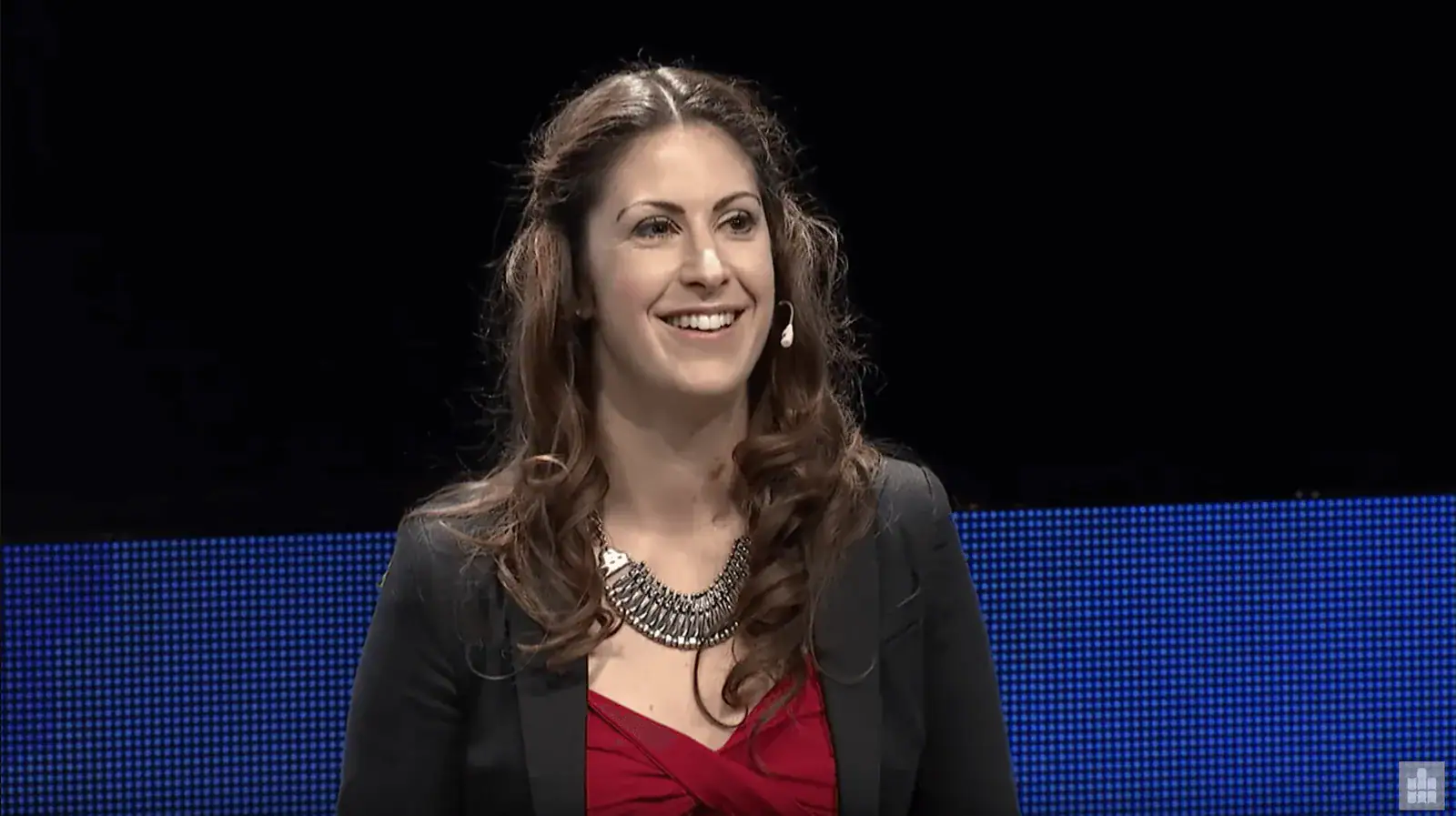 Madita van Hülsen sitzt auf dem Podium des Medienforums Mittweida 2014 vor blauer Leinwand