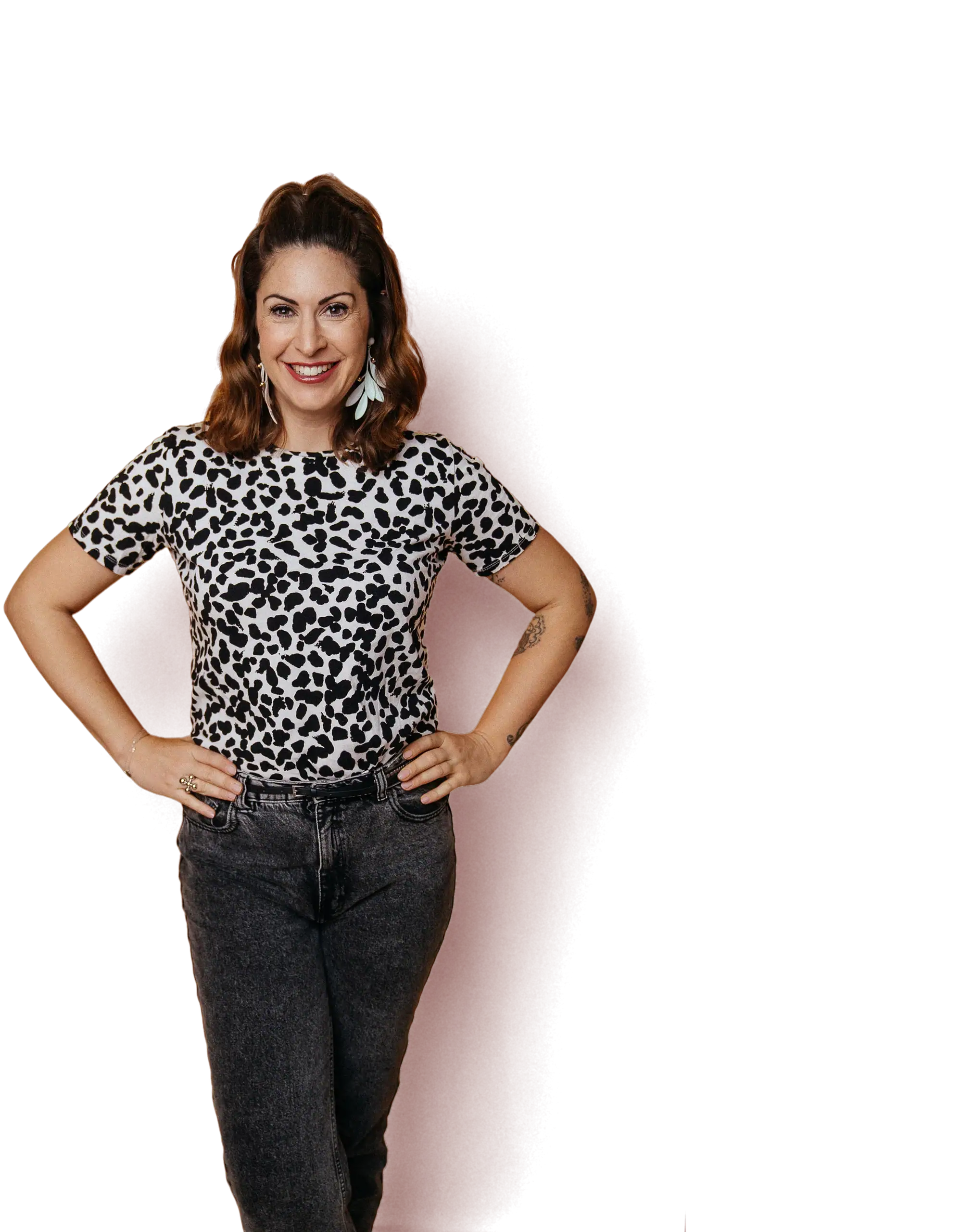 Madita van Hülsen, Moderatorin, steht lächelnd mit den Händen in den Hüften im gemusterten Shirt