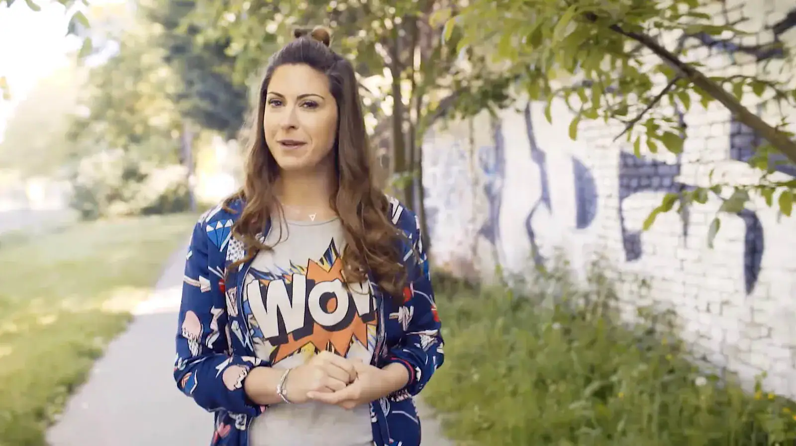 Madita van Hülsen moderiert im Freien auf einem Weg an einer Mauer, Showreel 2020