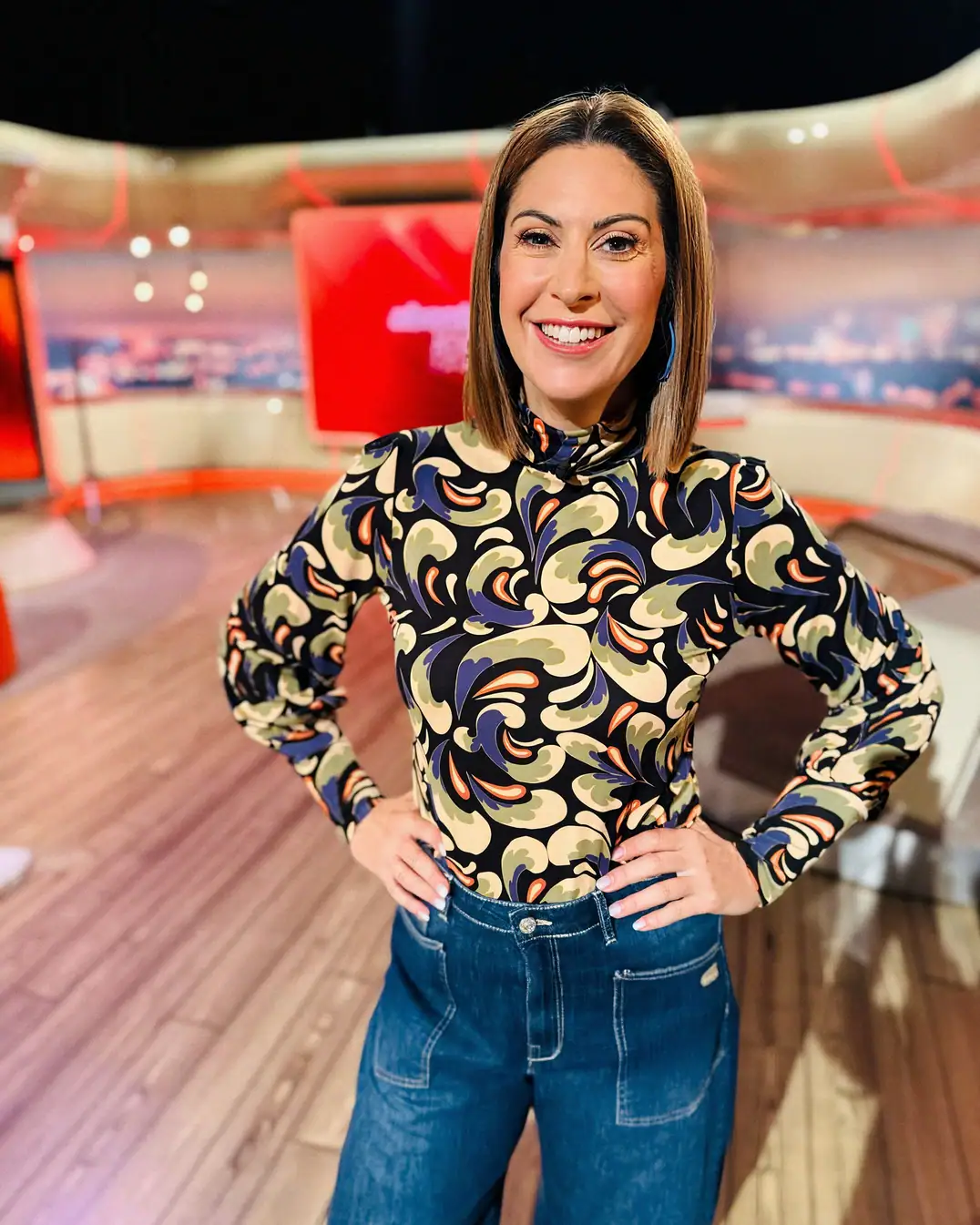 Madita van Hülsen steht lachend mit den Händen in die Hüften gestützt im Studio von Abenteuer Leben täglich